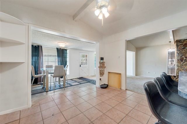 living room with ceiling fan, light tile patterned floors, and vaulted ceiling with beams