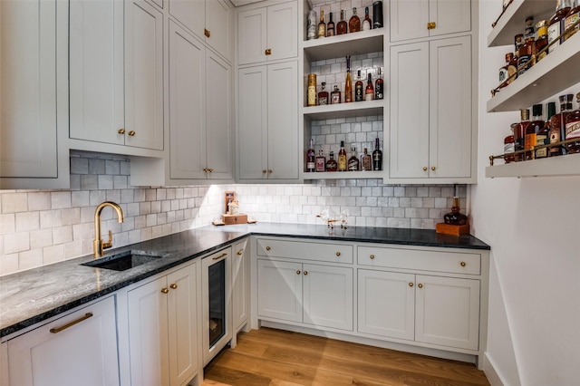 kitchen featuring sink, white cabinetry, and dark stone counters