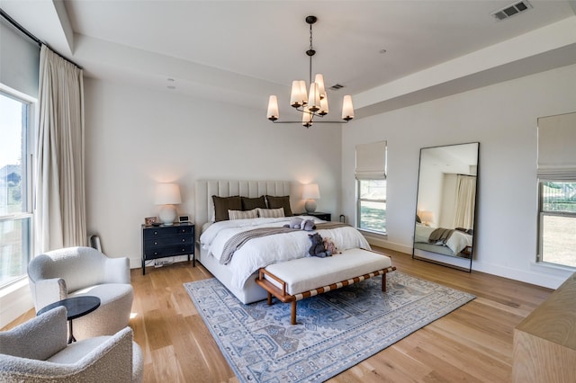 bedroom with a chandelier and light hardwood / wood-style flooring