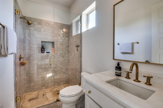 bathroom with toilet, an enclosed shower, and vanity