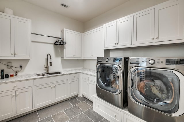 laundry room featuring sink, washing machine and dryer, and cabinets