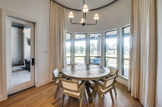 dining room with light wood-type flooring and an inviting chandelier