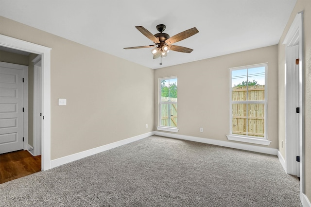 unfurnished room featuring ceiling fan and dark colored carpet