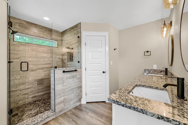 bathroom with vanity, an enclosed shower, and wood-type flooring