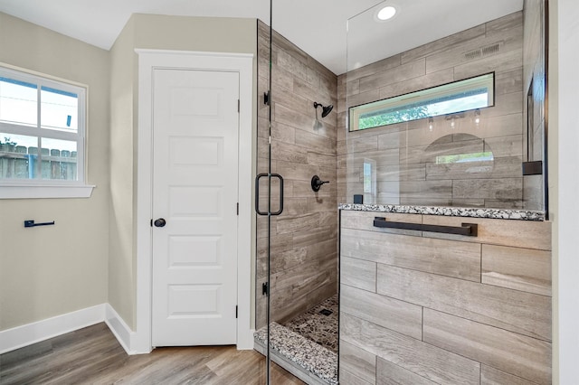 bathroom with an enclosed shower and hardwood / wood-style flooring