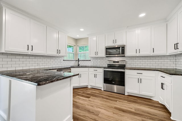 kitchen with light hardwood / wood-style flooring, white cabinets, stainless steel appliances, and sink