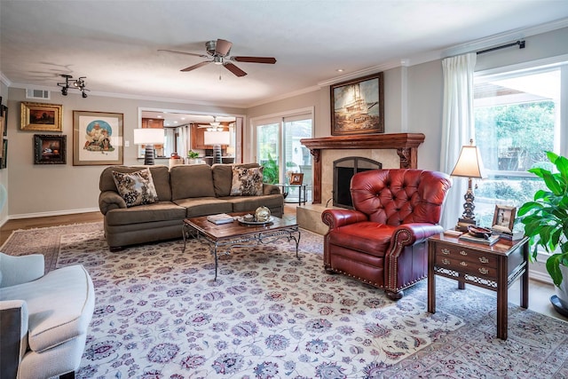 living room with ceiling fan, crown molding, and light wood-type flooring