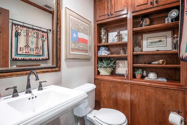 bathroom featuring sink, toilet, and crown molding