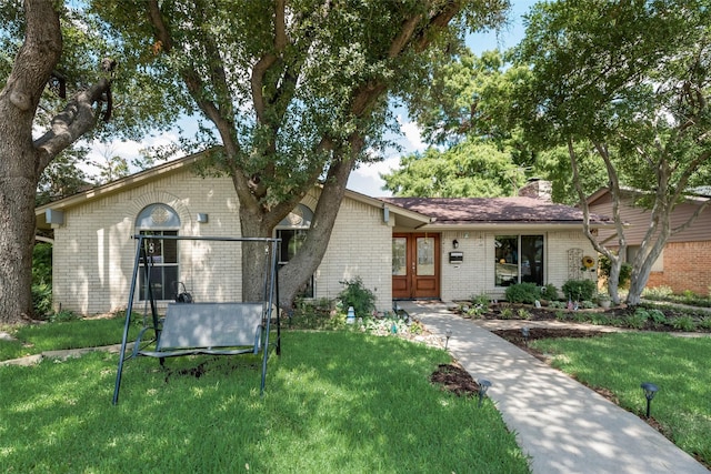 single story home with french doors and a front lawn