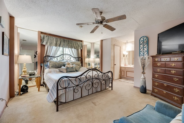 carpeted bedroom featuring ensuite bathroom, ceiling fan, and a textured ceiling