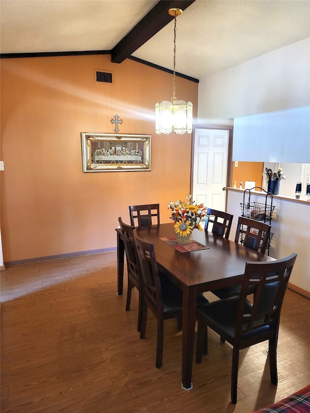 dining area featuring hardwood / wood-style floors, lofted ceiling with beams, and a notable chandelier