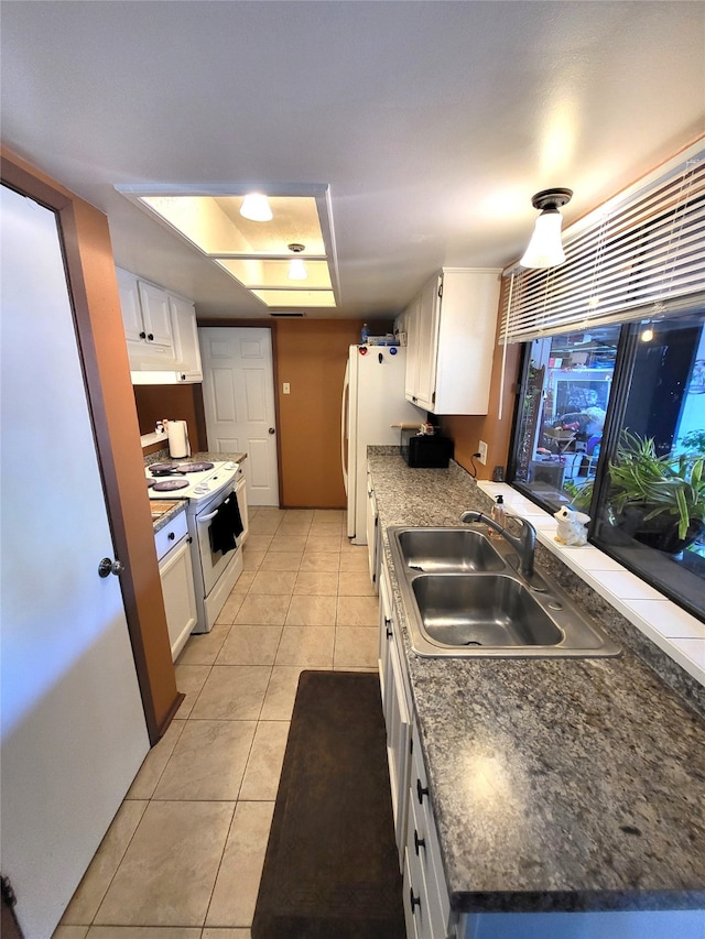 kitchen featuring white cabinets, light tile patterned flooring, white range, and sink