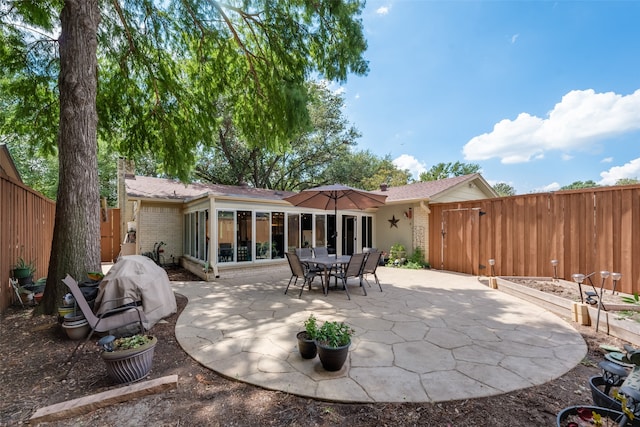 back of property featuring a sunroom and a patio