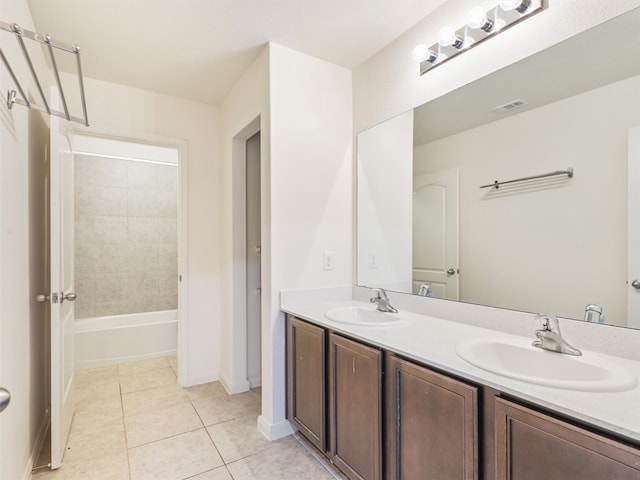 bathroom with tile patterned flooring, vanity, and tiled shower / bath combo