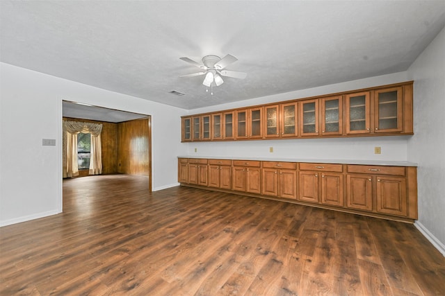 unfurnished living room with dark wood-type flooring, ceiling fan, and a textured ceiling