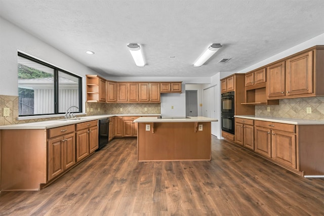 kitchen featuring a center island, dark hardwood / wood-style floors, decorative backsplash, and black appliances