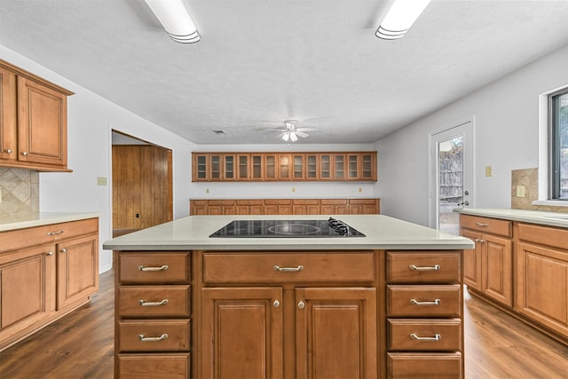 kitchen featuring a kitchen island, black electric cooktop, and dark hardwood / wood-style flooring