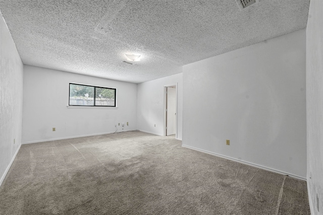 carpeted empty room featuring a textured ceiling