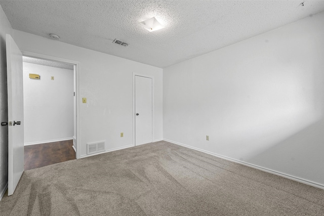 unfurnished room featuring a textured ceiling and carpet flooring