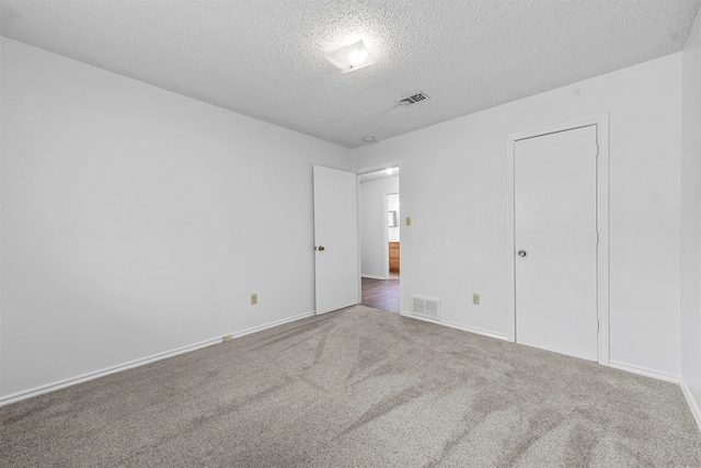 unfurnished bedroom with a textured ceiling and carpet floors