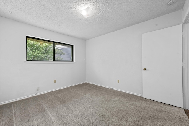 carpeted empty room featuring a textured ceiling