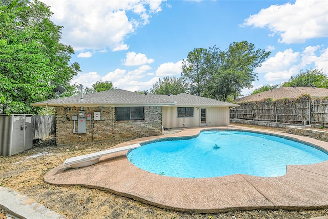 view of pool featuring a diving board and a patio