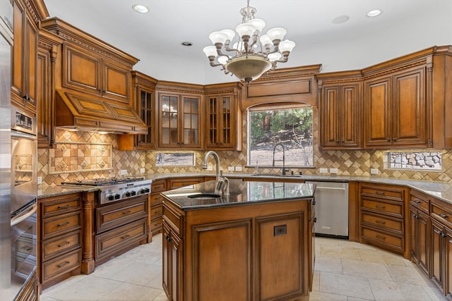 kitchen featuring tasteful backsplash, custom range hood, appliances with stainless steel finishes, a sink, and dark stone countertops