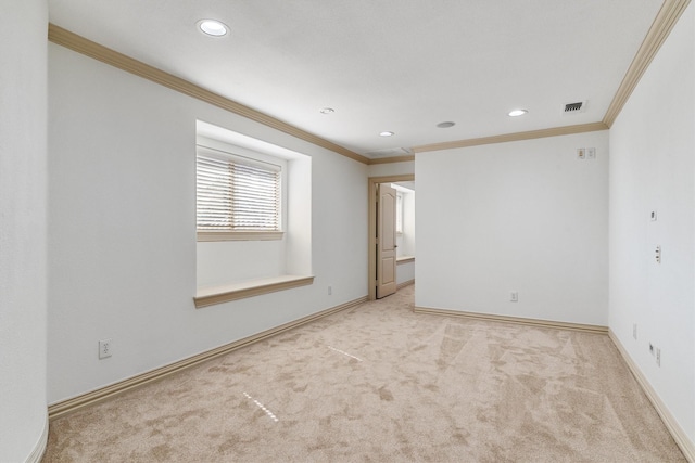 spare room with carpet floors, ornamental molding, visible vents, and baseboards