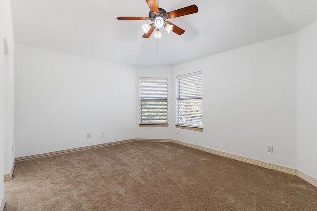 carpeted spare room with ceiling fan and baseboards