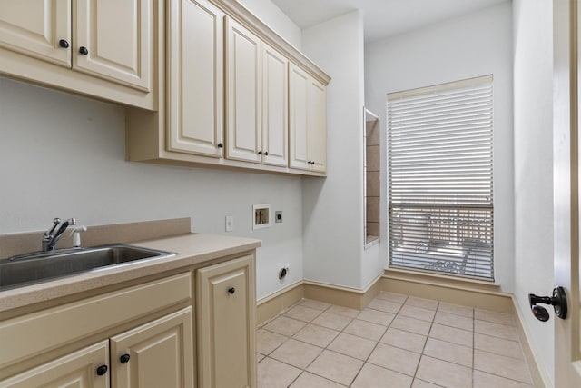 laundry area featuring light tile patterned floors, hookup for a washing machine, a sink, cabinet space, and electric dryer hookup