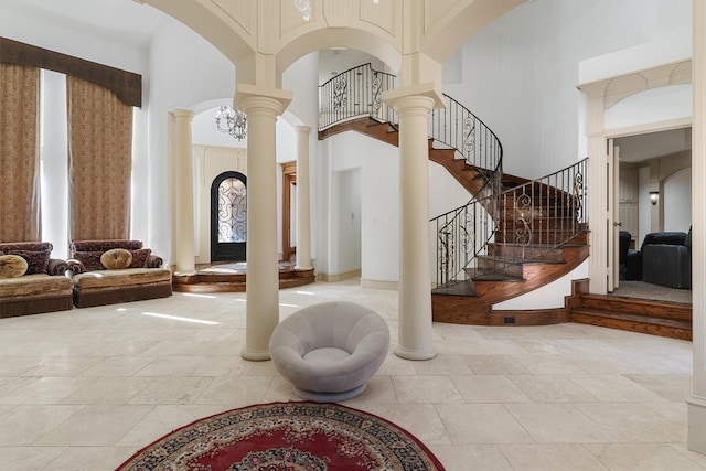 entryway with a towering ceiling, ornate columns, stairs, and arched walkways