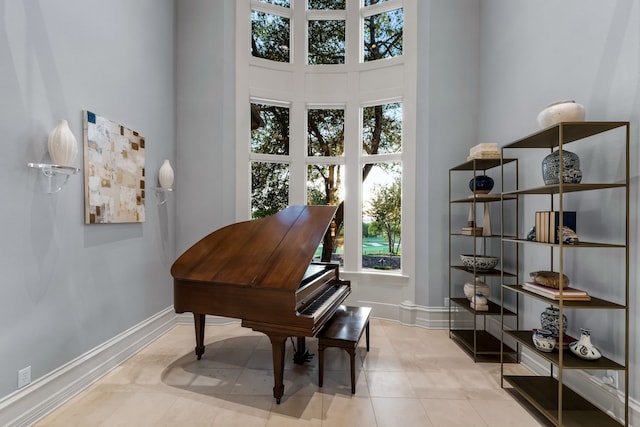 miscellaneous room featuring a towering ceiling and light tile patterned floors