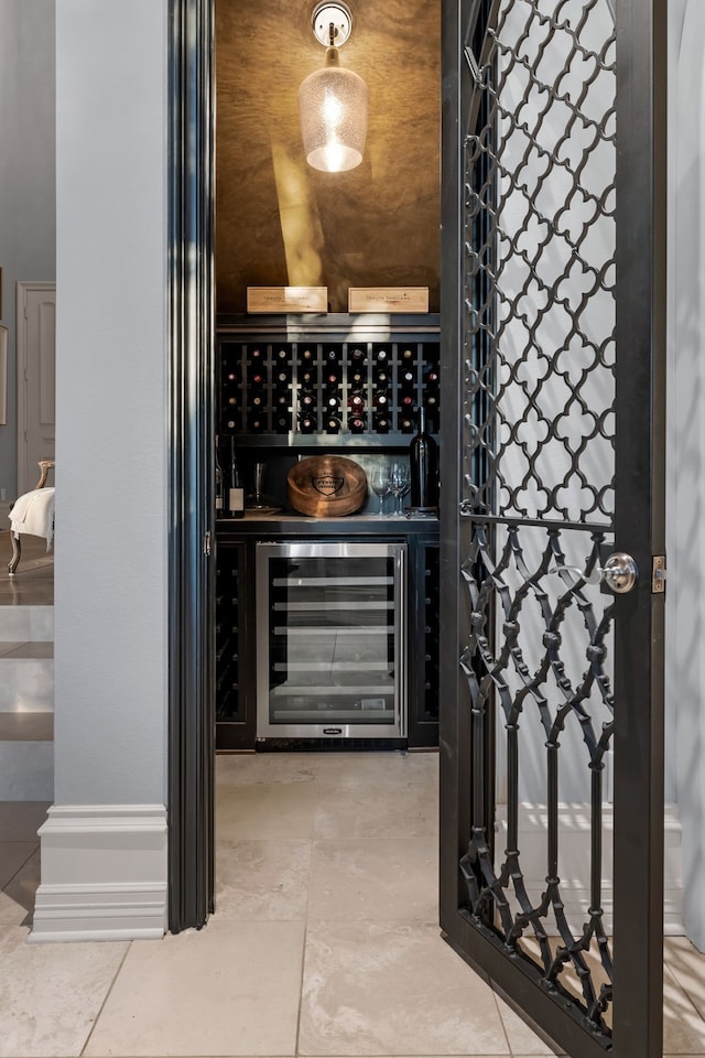 wine area with beverage cooler and tile patterned flooring