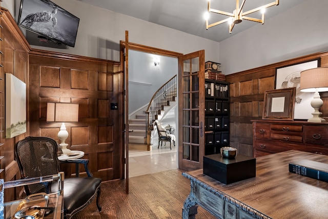 office area with an inviting chandelier, wood walls, and hardwood / wood-style floors