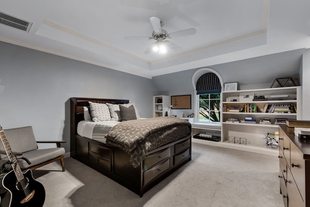 carpeted bedroom featuring ornamental molding, a tray ceiling, and ceiling fan