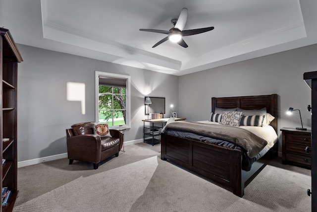 carpeted bedroom featuring ornamental molding, a tray ceiling, and ceiling fan