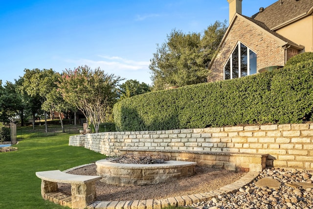 exterior space with a fire pit and a lawn