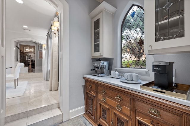 kitchen featuring a healthy amount of sunlight, light tile patterned flooring, and white cabinetry