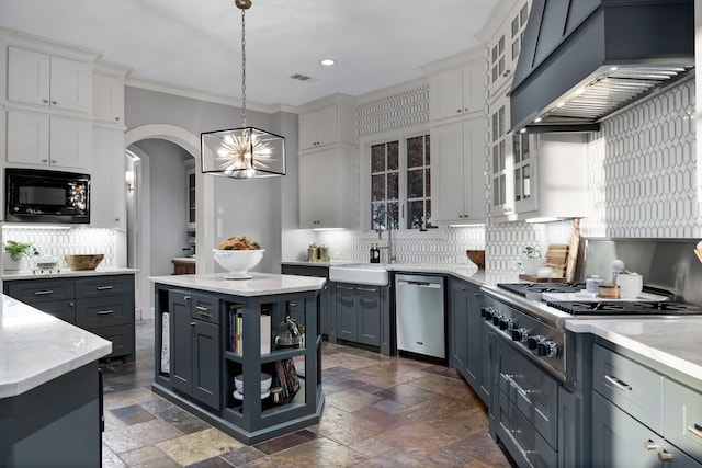 kitchen with decorative light fixtures, appliances with stainless steel finishes, a center island, and white cabinetry