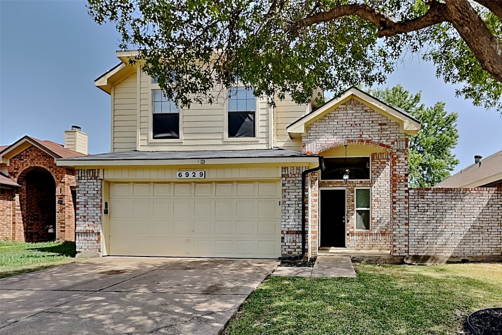 view of front of house with a garage and a front lawn