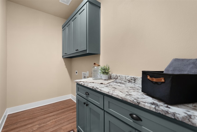 interior space with hardwood / wood-style floors, hookup for an electric dryer, cabinets, and hookup for a washing machine