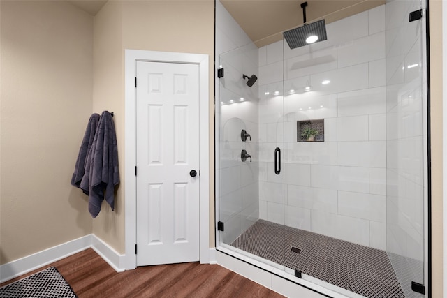 bathroom featuring an enclosed shower and hardwood / wood-style flooring