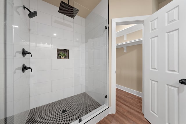 bathroom featuring a tile shower and hardwood / wood-style floors