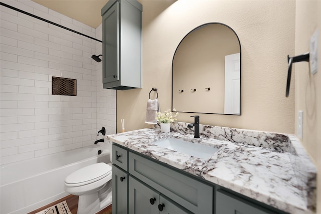 full bathroom with tiled shower / bath, vanity, toilet, and wood-type flooring