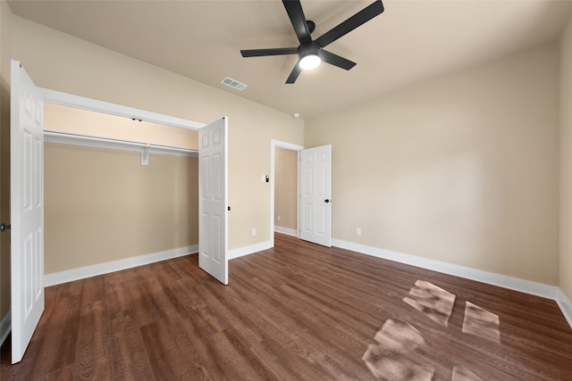 unfurnished bedroom with ceiling fan, dark hardwood / wood-style floors, and a closet