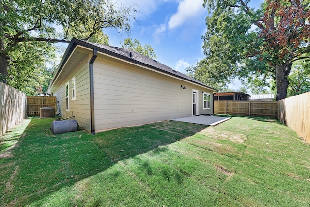 rear view of house with a patio area, a lawn, and central AC