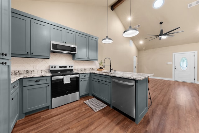 kitchen with hanging light fixtures, stainless steel appliances, sink, kitchen peninsula, and ceiling fan