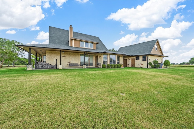 rear view of property featuring a lawn