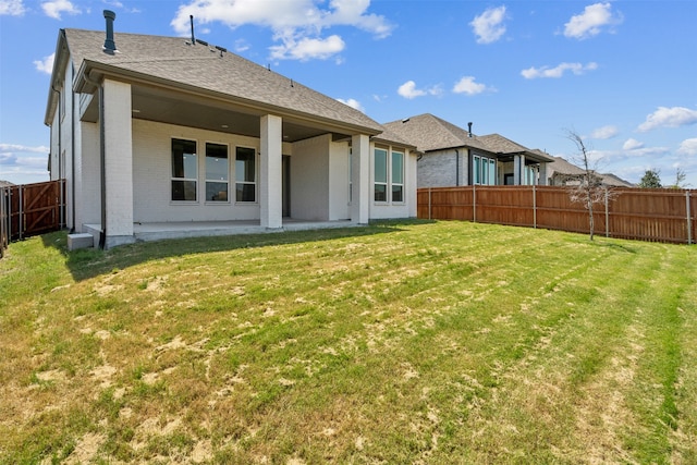 back of house featuring a yard and a patio