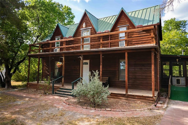 log home featuring a standing seam roof, a porch, and metal roof